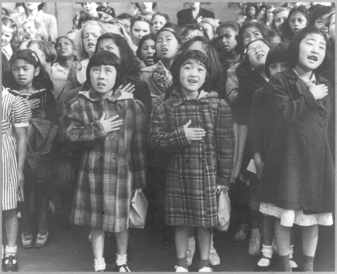 Dorothea Lange. “San Francisco, Calif., April 1942 - Children of the Weill public school, from the so-called international settlement, shown in a flag pledge ceremony. Some of them are evacuees of Japanese ancestry who will be housed in War relocation authority centers for the duration.”