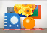 Tom Wesselmann. Still Life #57. 1969–70. Oil on canvas and base of acrylic paint on carpet, in six sections. Gift of the artist. © Tom Wesselmann/Licensed by VAGA, New York, NY Alt Text: A gallery installation view of five shaped paintings arranged as larger than life sized objects placed on a red checkered picnic blanket. On the left is a periwinkle blue radio, with four lighter blue buttons on the left side and a large circular speaker in the center with two small knobs below. Behind it is a silver metallic switch plate. In the back center is a blue and white vase holding a spray of yellow daffodils. To the right of the flowers is a red-framed window in the shape of an acute triangle, with an abstracted blue and green landscape. Below the window and flowers is an orange, with the navel facing up at the one o&#39;clock position.