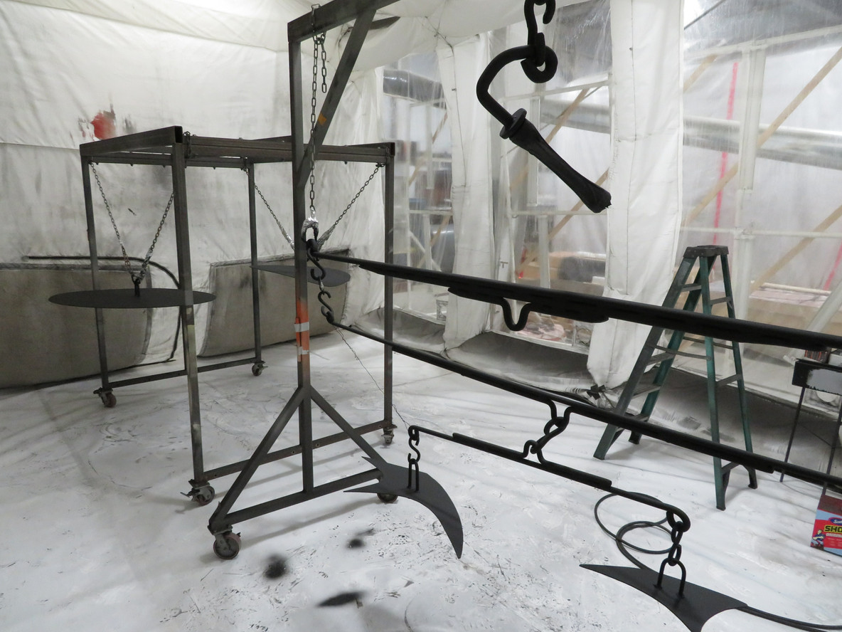 Sculpture elements hang in the “spray booth” at Monumenta Art Conservation. Photo: Abigail Mack