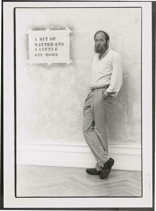 Lawrence Weiner in front of A BIT OF MATTER AND A LITTLE BIT MORE (1976), Kunsthalle Bern, Works &amp; Reconstructions, August 19–October 16, 1983