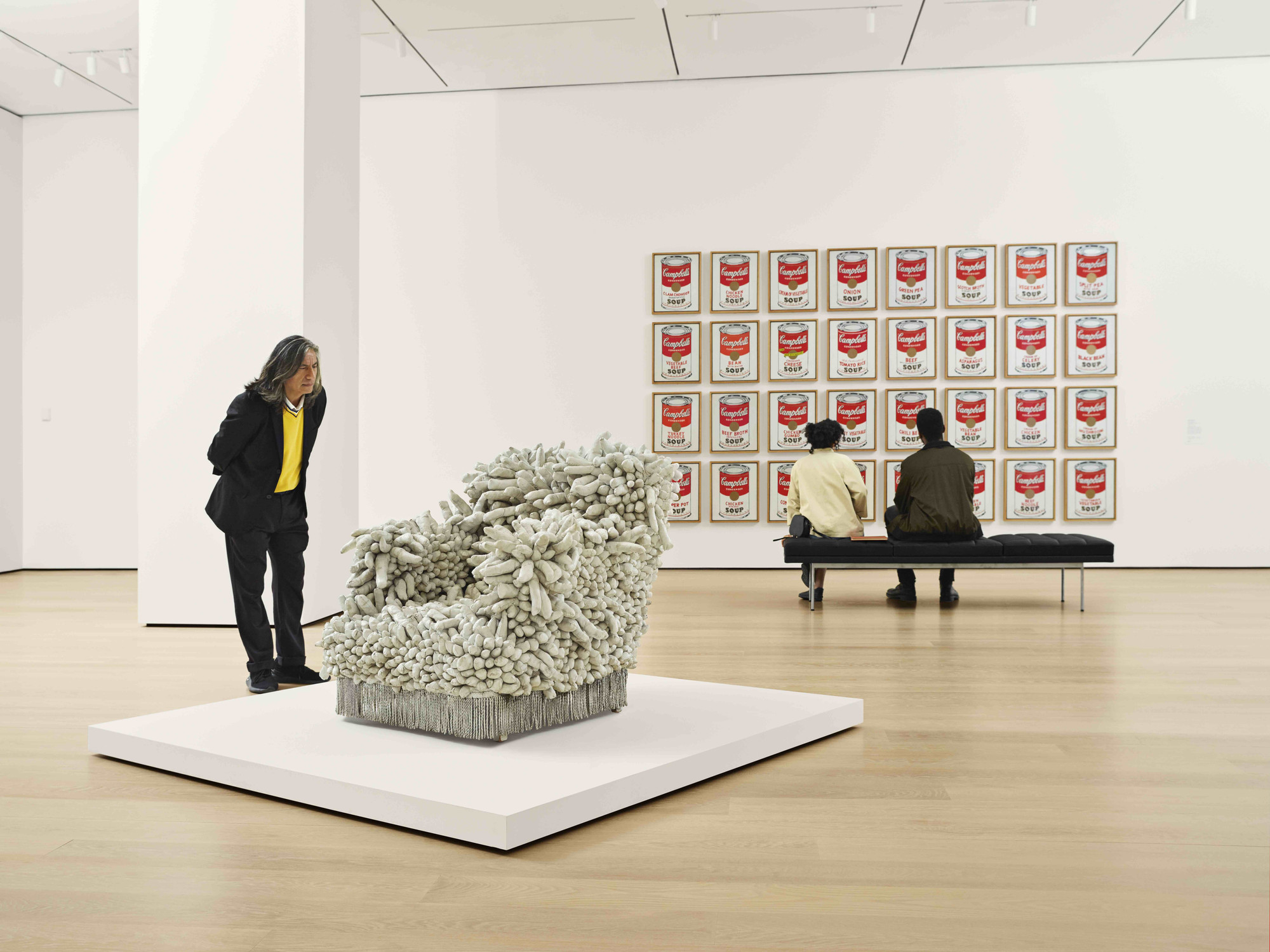 A view of the fourth-floor collection galleries. Shown (from left): Yayoi Kusama. Accumulation No. 1. 1962. Sewn stuffed fabric, paint, and chair fringe. Gift of William B. Jaffe and Evelyn A. J. Hall (by exchange). © 2019 Yayoi Kusama; Andy Warhol. Campbell’s Soup Cans. 1962. Acrylic with metallic enamel paint on canvas, 32 panels. Partial gift of Irving Blum Additional funding provided by Nelson A. Rockefeller Bequest, gift of Mr. and Mrs. William A. M. Burden, Abby Aldrich Rockefeller Fund, gift of Nina and Gordon Bunshaft, acquired through the Lillie P. Bliss Bequest, Philip Johnson Fund, Frances R. Keech Bequest, gift of Mrs. Bliss Parkinson, and Florence B. Wesley Bequest (all by exchange). © 2019 Andy Warhol Foundation/ARS, NY/TM Licensed by Campbell’s Soup Co. All rights reserved. Photo: Noah Kalina